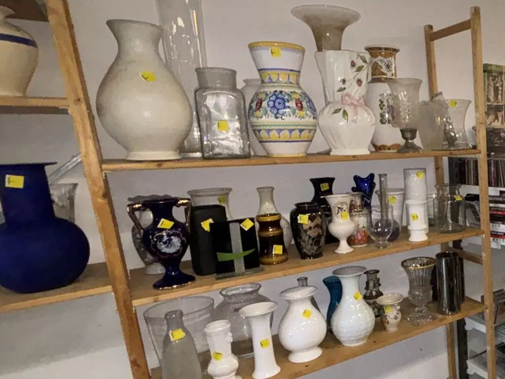 Vazen en glaswerk op houten stellingen
