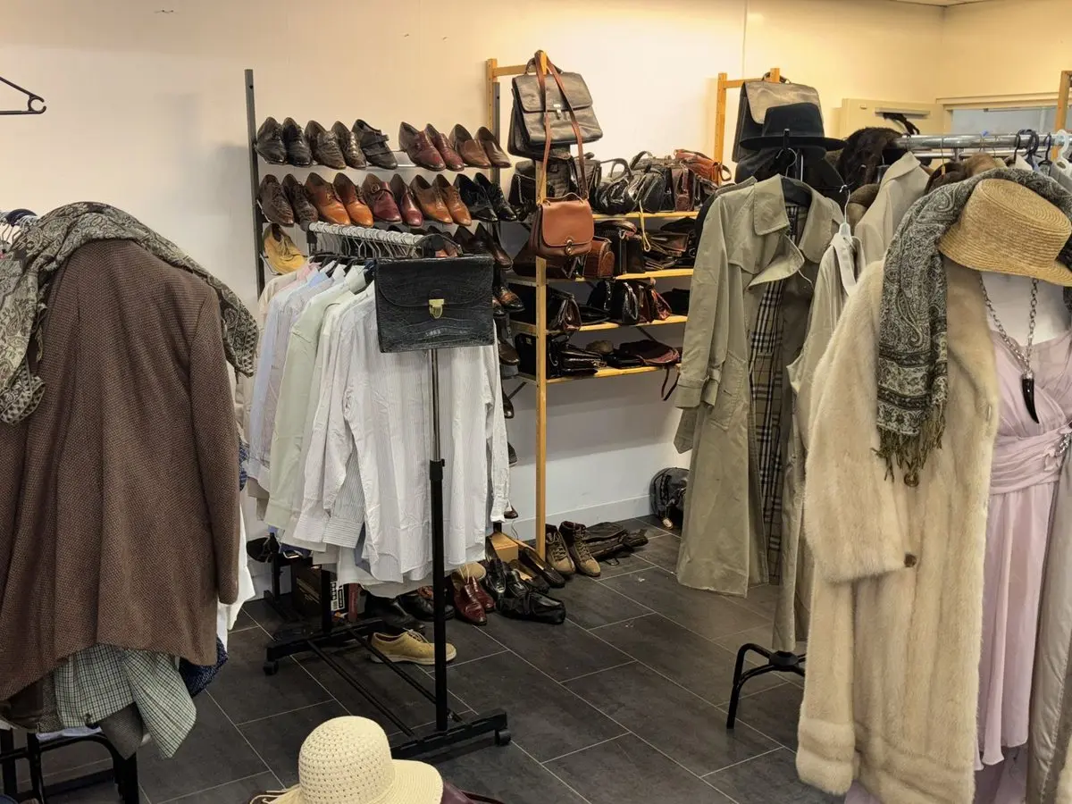 Rekken met kleding, schoenen en tassen in de winkel